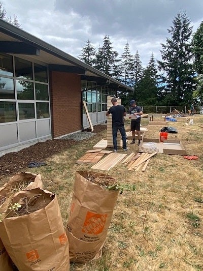 volunteers building garden tool shed