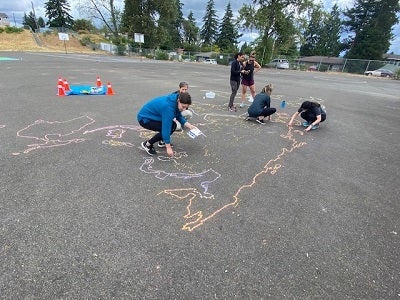 volunteers drawing the outline of the maps in chalk